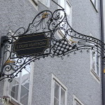 Salzburg, ulica Getreidegasse, szyldy sklepowe i hotelowe
